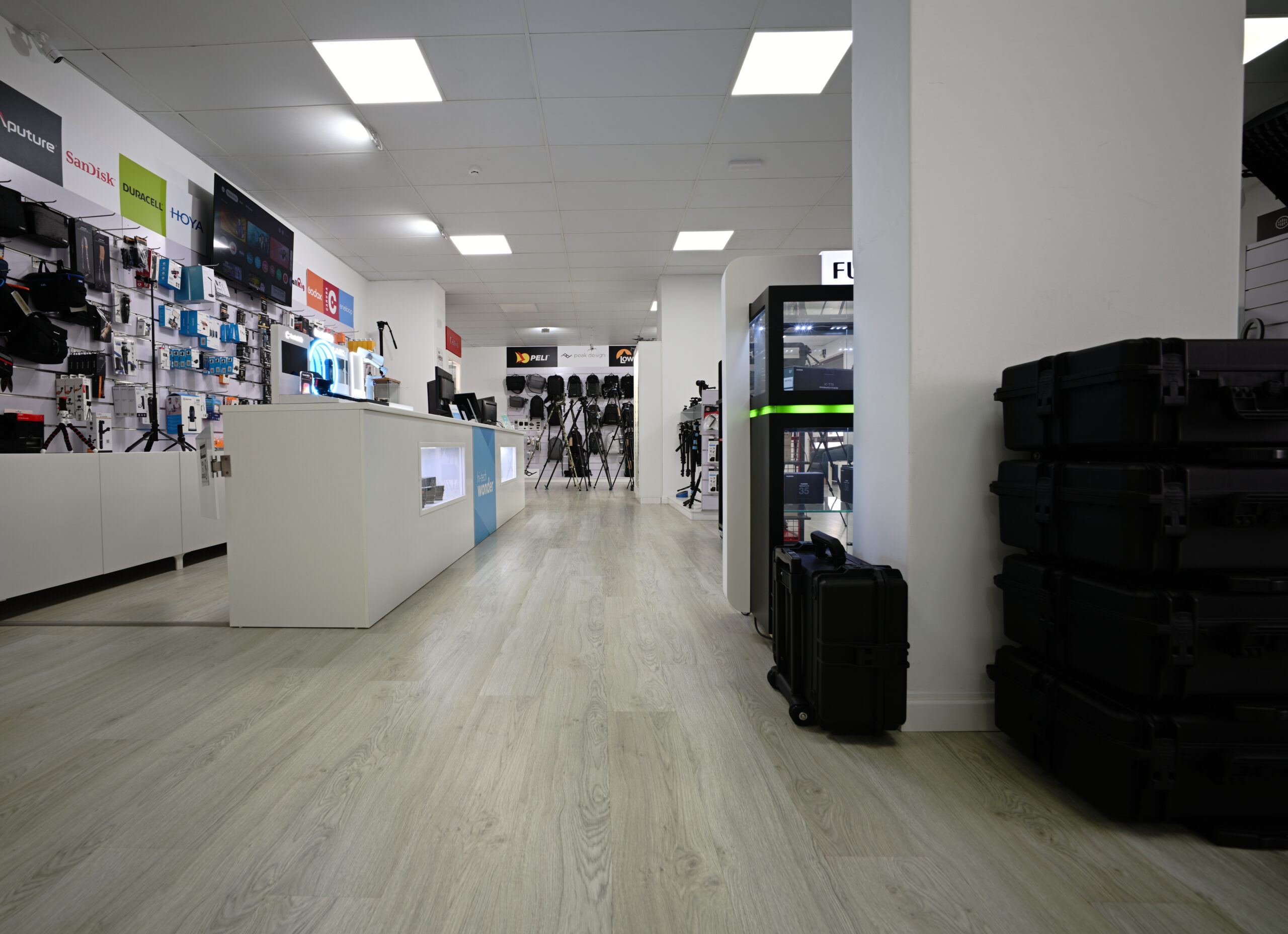 Lateral do balcão de atendimento da loja hi-techwonder, com expositores de produtos.